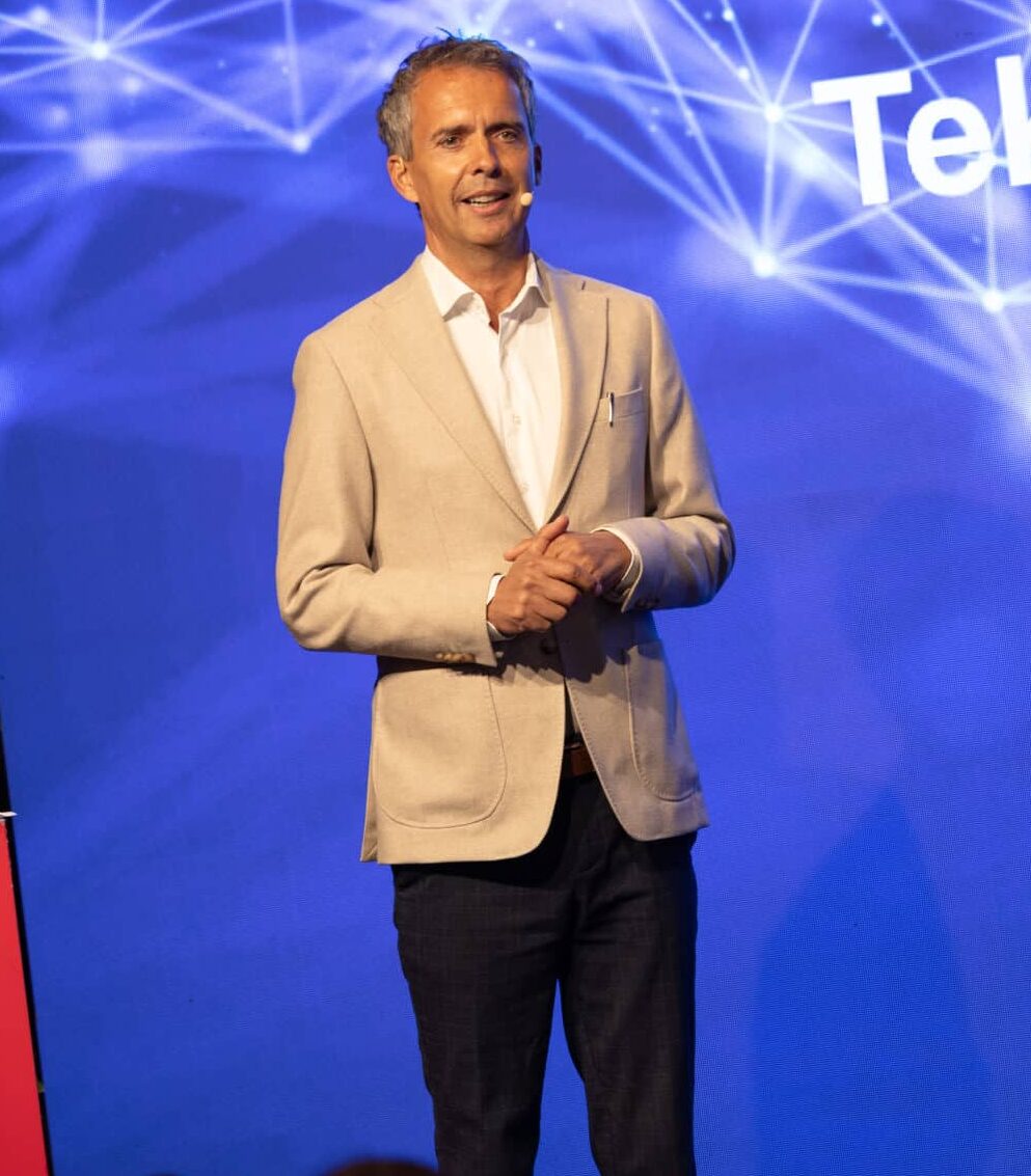 Jarle Roheim Håkonsen på scenen under årskonferansen til TEK Norge tidligere i år, foran blå skjerm.