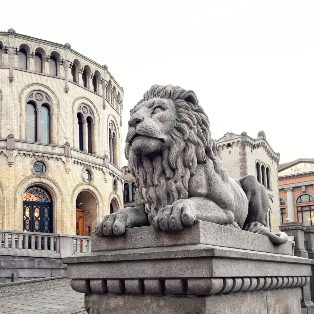 Bilde av stortinget, med løven i fokus foran stortingsbygget