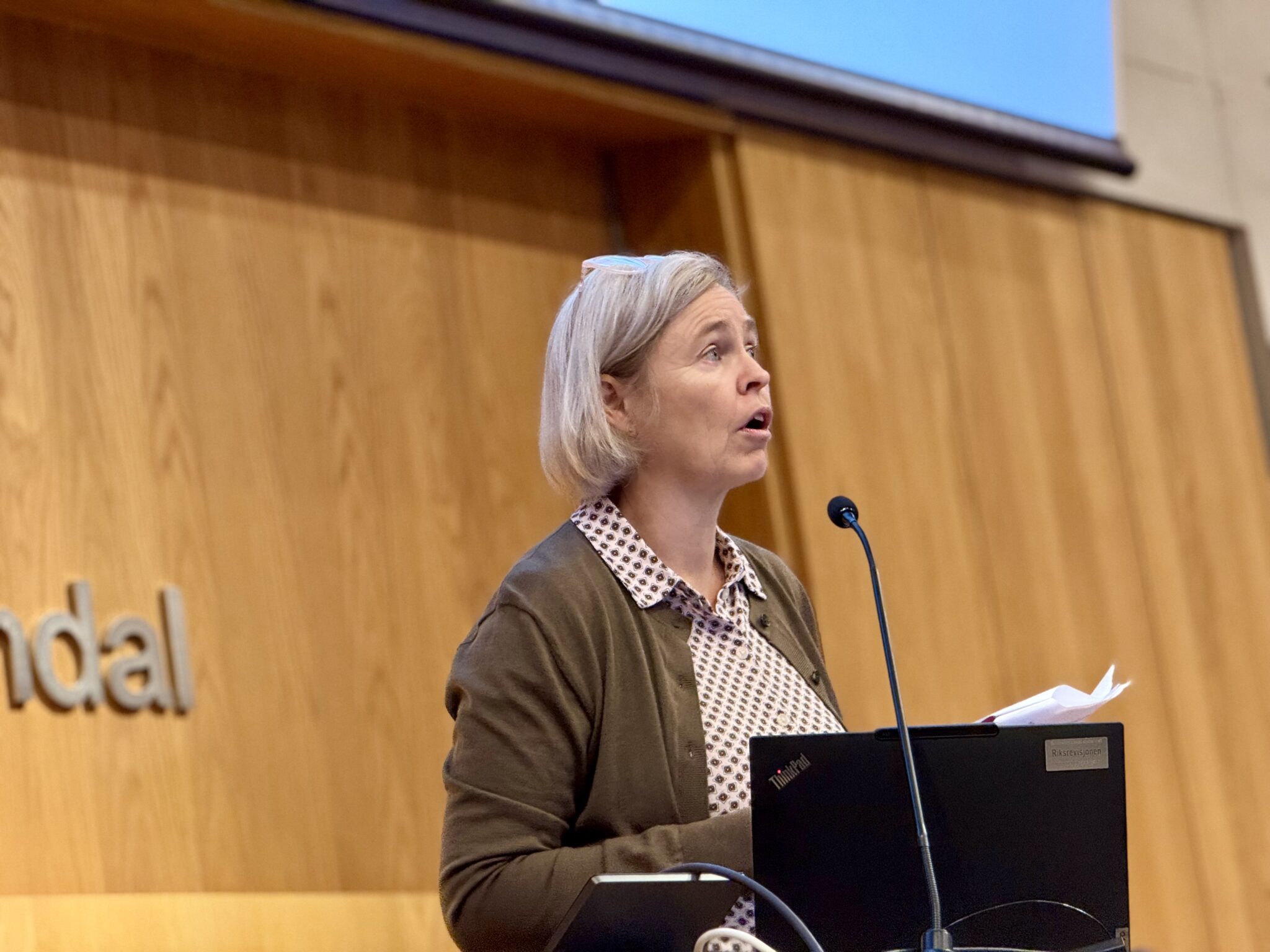 Nina Jensløkken i Riksrevisjonen står på podiet hos Gyldendal.