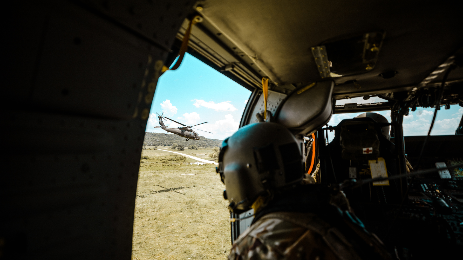 Bilde av soldat i helikopter som kikker ned på mark